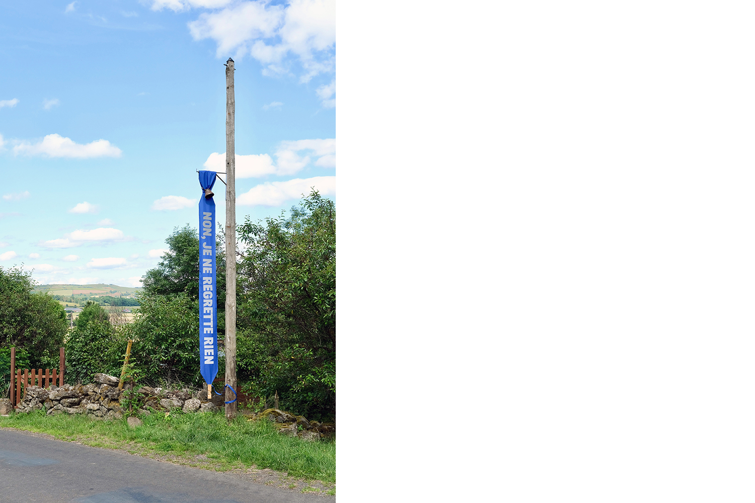 banderole "Non, je ne regrette rien" installée à la sortie du village